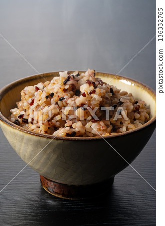 一碗熱氣騰騰、新鮮煮熟的雜糧米飯，豎幅照片，背景為深色。 136332765