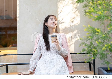 Young woman relaxing on the cafe terrace 136333320