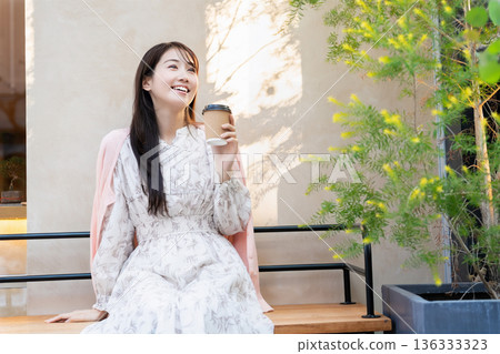 在咖啡館露台上放鬆的年輕女子 在咖啡館露台上放鬆的年輕女子 136333323