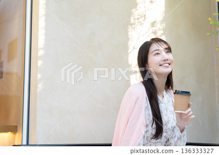 Young woman relaxing on the cafe terrace Young woman relaxing on the cafe terrace 136333327
