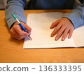 Hands of a child writing in a notebook 136333395