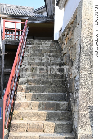 Stone steps that mark the castle's history: the contrast between the red handrail and the old stone walls Stone steps that mark the castle's history: the contrast between the red handrail and the old stone walls 136333433