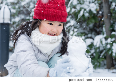 Kid making a snowman 136333509