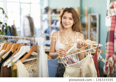 Young girl choosing summer dress in clothing store 136333595