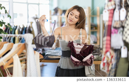 Young woman chooses underwear in clothing store Young woman chooses underwear in clothing store 136333611
