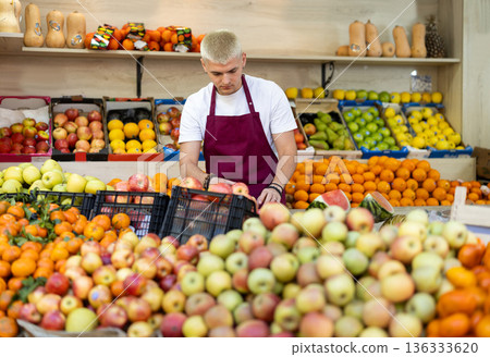 Guy shop seller puts apple goods on display case 136333620