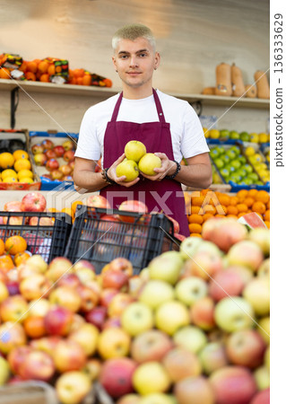 Guy shop seller puts apple goods on display case Guy shop seller puts apple goods on display case 136333629