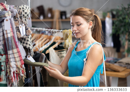 Woman choosing a scarf in a store 136333633