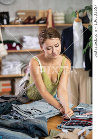 Woman shopping in clothing department, buying denim pantalones 136333657