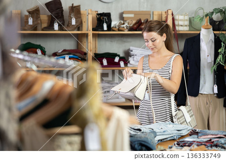 Young women choosing handbag in store Young women choosing handbag in store 136333749