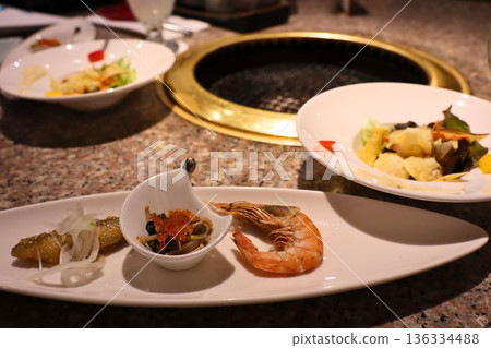 Tabletop grill and beautifully presented appetizers at a yakiniku restaurant Tabletop grill and beautifully presented appetizers at a yakiniku restaurant 136334488