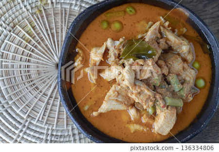 A Panang curry with chicken, long beans, turkey berries, and kaffir lime leaves is served in a ceramic bowl. A Panang curry with chicken, long beans, turkey berries, and kaffir lime leaves is served in a ceramic bowl. 136334806