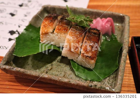 Fragrantly grilled mackerel sushi (served in a Japanese dish and with leaves) 136335201