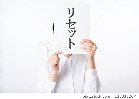 一個身穿白襯衫的人拿著一張紙，上面寫著「重置」二字。 136335267