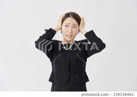Woman in mourning clothes holding her head, white background Woman in mourning clothes holding her head, white background 136336462