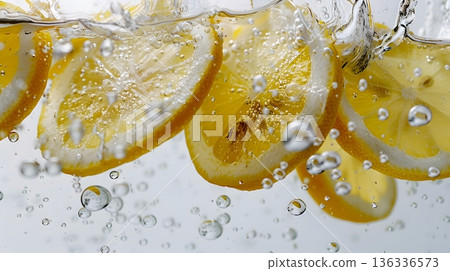Fresh lemon falling into carbonated water: a refreshing splash captured in high-speed photography Fresh lemon falling into carbonated water: a refreshing splash captured in high-speed photography 136336573