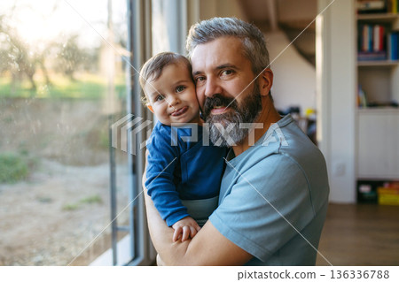 Dad holding his little toddler son in arms. Dad holding his little toddler son in arms. 136336788