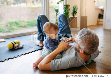 Father playing with little son on floor. Father playing with little son on floor. 136336793