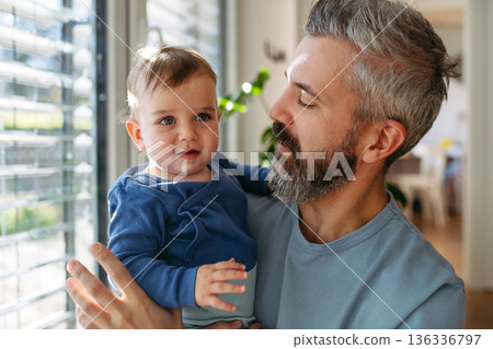 Dad holding his little toddler son in arms. Dad holding his little toddler son in arms. 136336797