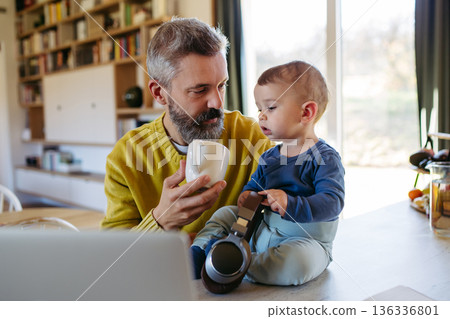 Dad working from homeoffice and taking care of toddler. Dad working from homeoffice and taking care of toddler. 136336801