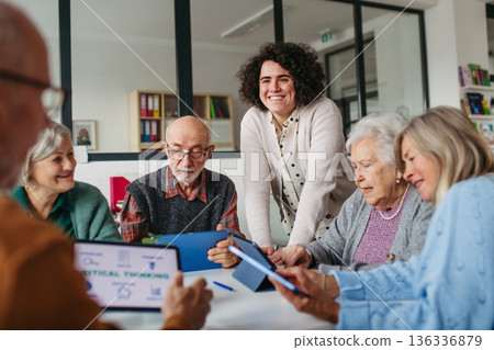 Tutor teaching seniors about phone scams and digital safety. 136336879