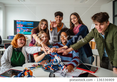 Teen students working as a team on robotics project in classroom. Teen students working as a team on robotics project in classroom. 136336909