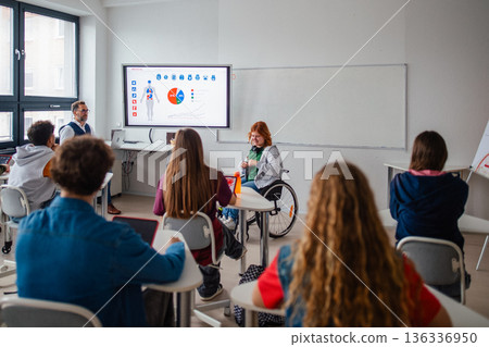 High school student in wheelchair leading classroom discussion. High school student in wheelchair leading classroom discussion. 136336950