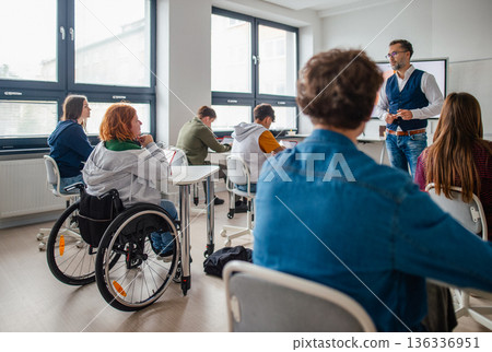 Inclusive classroom scene with student using wheelchair. 136336951