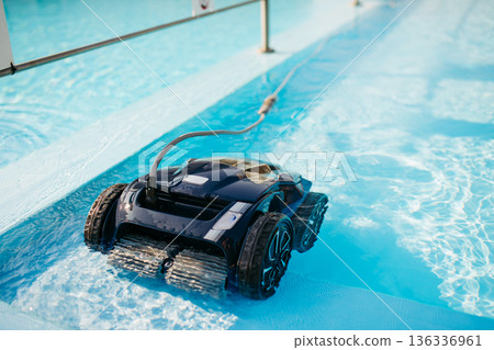 Robotic pool cleaner working underwater to keep swimming pool clean. Robotic pool cleaner working underwater to keep swimming pool clean. 136336961