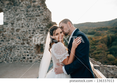 Bride and groom dancing, looking at each other. Wedding couple standing outside near ruins. Bride and groom dancing, looking at each other. Wedding couple standing outside near ruins. 136337013