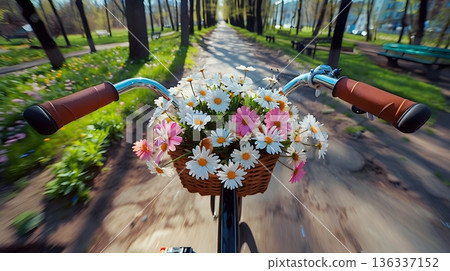 Riding a bicycle carrying a flower basket through a spring park 136337152
