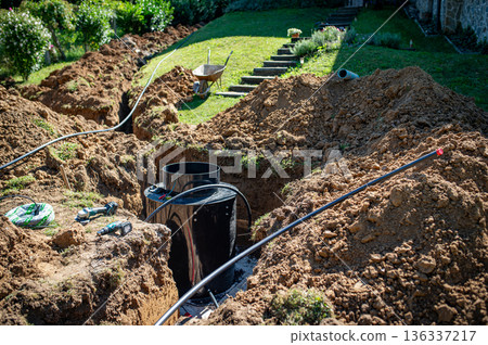 Installing underground utility shaft during construction work. Installing underground utility shaft during construction work. 136337217