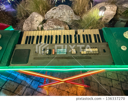 Vintage electronic keyboard with neon lights outdoors at night 136337270