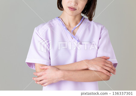 一位身穿醫用工作服的中年女護士，她很擔心。 136337301