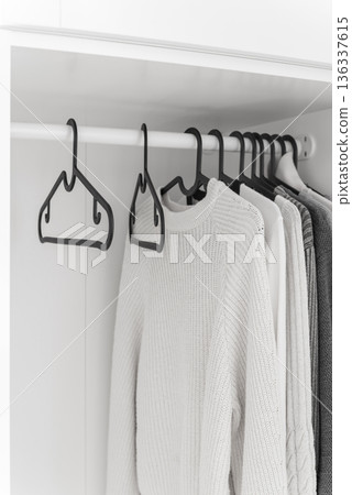 Wardrobe with sweaters on hangers 136337615