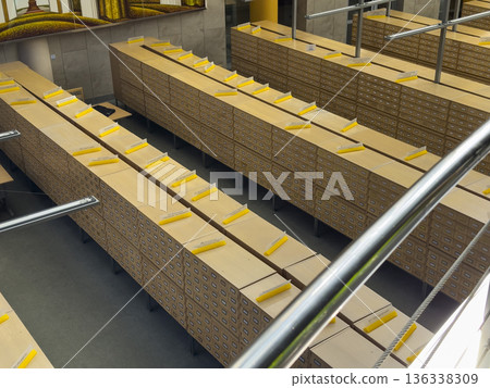 Top view of extensive wooden card catalog cabinets arranged in parallel rows inside a large archive 136338309