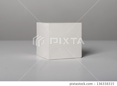 white cube with clean straight edges placed on a neutral studio surface. Simple geometric solid with 136338315