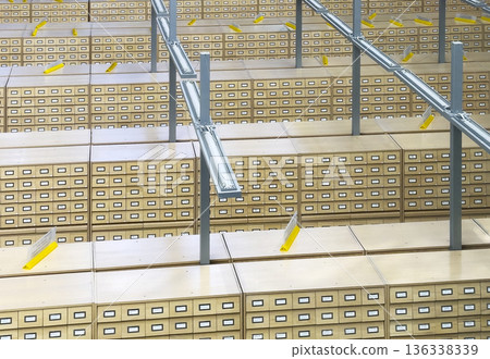 Large archive interior with extensive rows of wooden card catalog drawers and metal structural Large archive interior with extensive rows of wooden card catalog drawers and metal structural 136338339