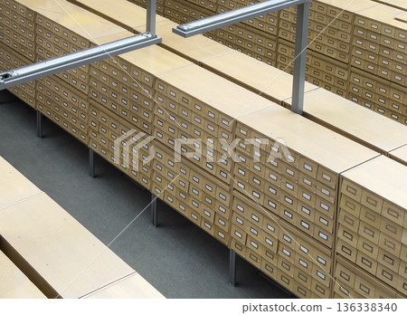 Large archive storage system with rows of wooden card catalog drawers arranged in a geometric Large archive storage system with rows of wooden card catalog drawers arranged in a geometric 136338340