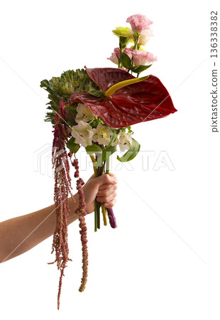 Hand holding a mixed floral bouquet with anthurium, alstroemeria, carnations, amaranthus, and 136338382