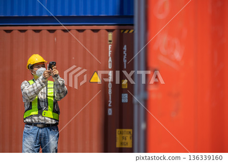 Foreman or worker work at Container cargo site check up goods in container.  136339160