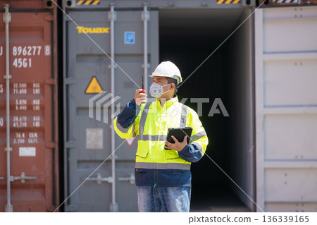 Foreman or worker work at Container cargo site check up goods in container.  136339165