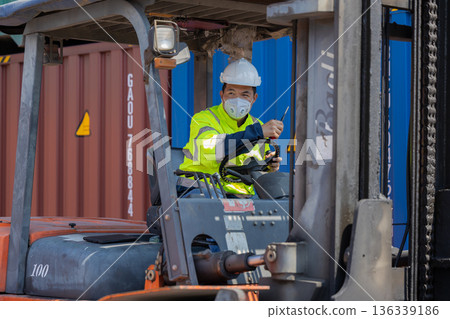Foreman or worker work at Container cargo site check up goods in container.  136339186
