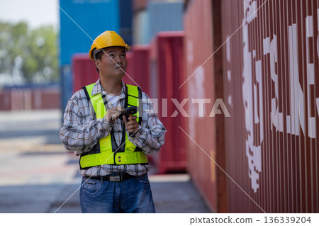 Foreman or worker work at Container cargo site check up goods in container.  136339204