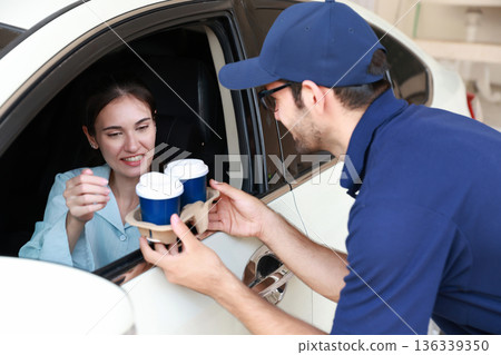 Hand Man in car receiving coffee in drive thru fast food restaurant.  136339350
