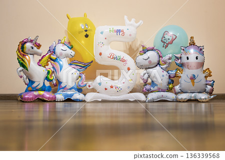 Vibrant assortment of unicorn foil balloons and a large number five Vibrant assortment of unicorn foil balloons and a large number five 136339568