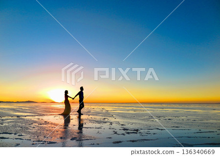 Wedding photo of a couple walking hand in hand at sunset on the Uyuni Salt Flats Wedding photo of a couple walking hand in hand at sunset on the Uyuni Salt Flats 136340669