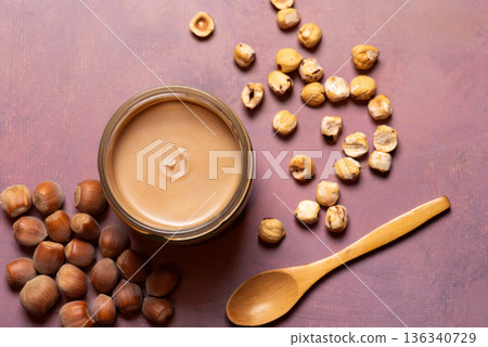 Aromatic Hazelnut Cream In A Jar With Scattered Nuts And Spoon Aromatic Hazelnut Cream In A Jar With Scattered Nuts And Spoon 136340729