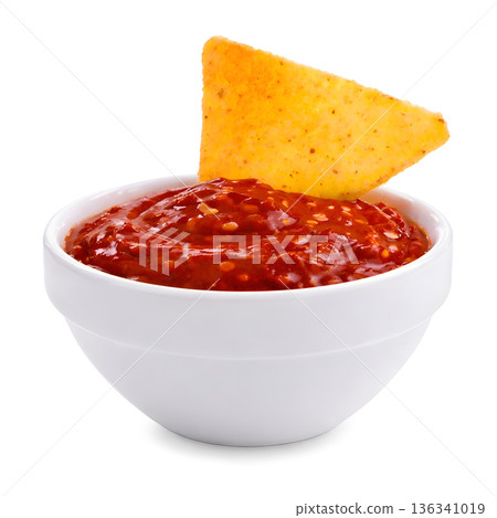 Nacho Chip Dipping in Spicy Chili Sauce 136341019