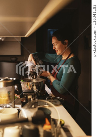Woman Cooking Mussels in Kitchen Pot 136341182